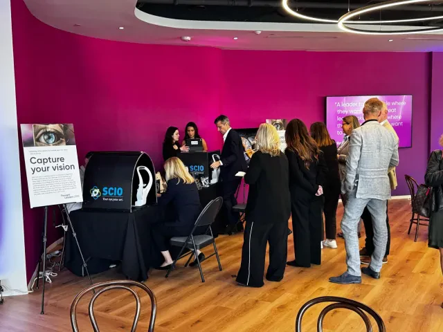 Team members receiving personalized iris artwork at a corporate event